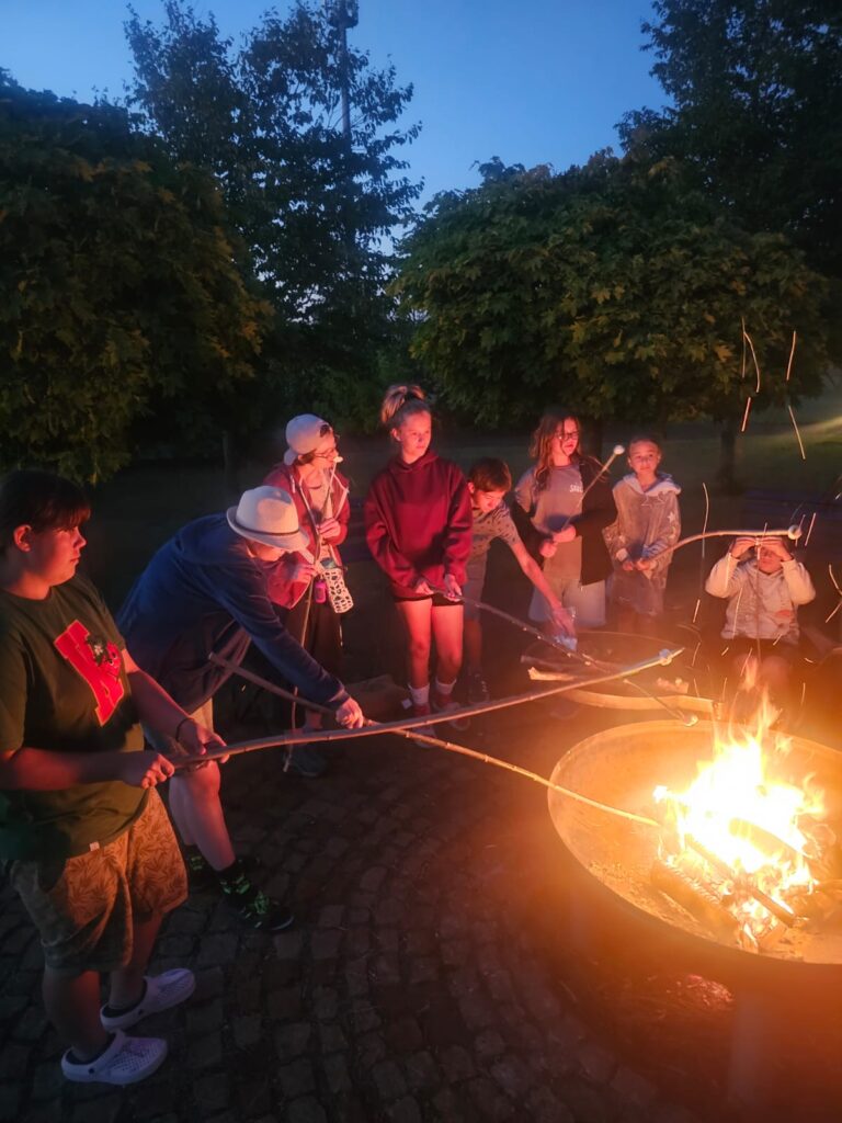 Junge Menschen sitzen an einem Lagerfeuer