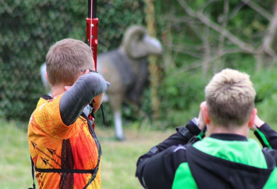 Ein Bogensportler steht im Vollauszug beim Schuss auf einen Bock